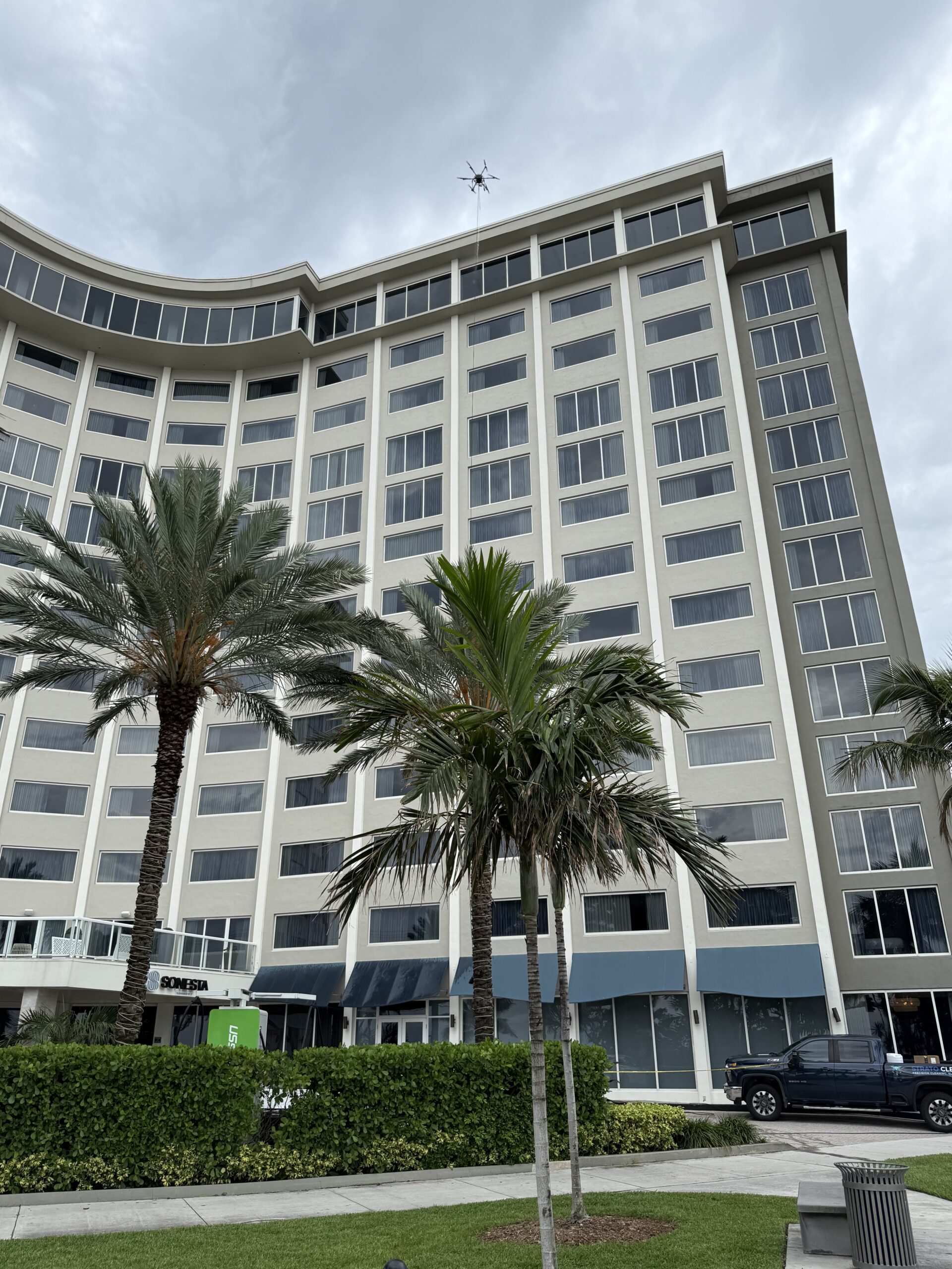 Drone window washing on a multi-story oceanfront South Florida hotel facade